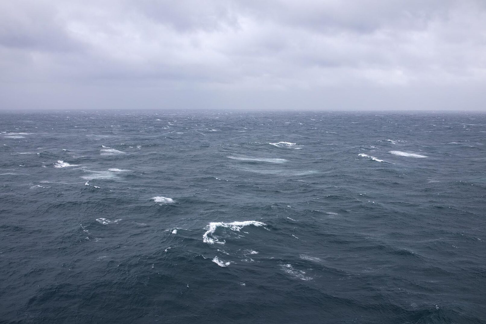 Sea with waves and clouds. work by Elizabeth Withstandley, Searching for the Miraculous, (video still) 3 channel video installation, TRT 18 minutes, 2020