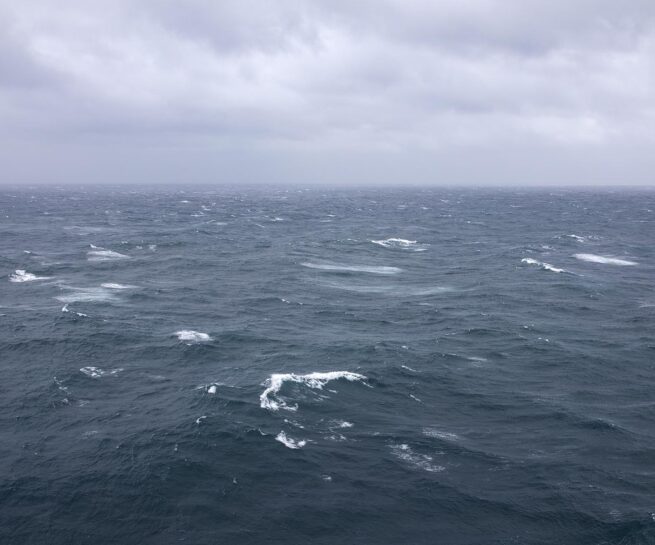 Sea with waves and clouds. work by Elizabeth Withstandley, Searching for the Miraculous, (video still) 3 channel video installation, TRT 18 minutes, 2020