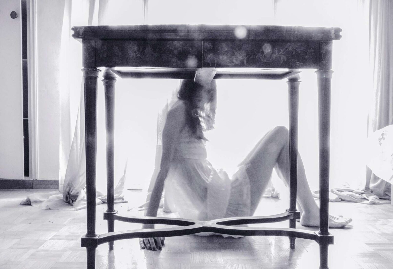 a female figure siting on the floor. in front of the frame there is a table. Iliana Psoma, 11257